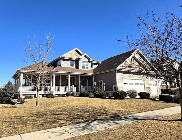 view of front of house with a porch, a garage, and a front lawn