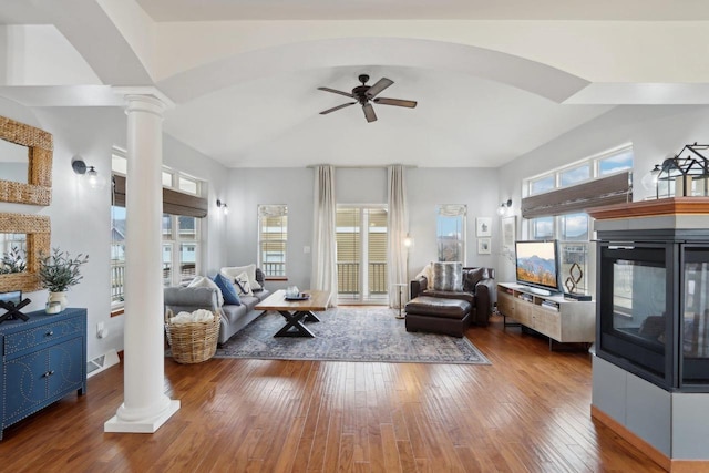 living area featuring visible vents, ornate columns, ceiling fan, hardwood / wood-style flooring, and vaulted ceiling