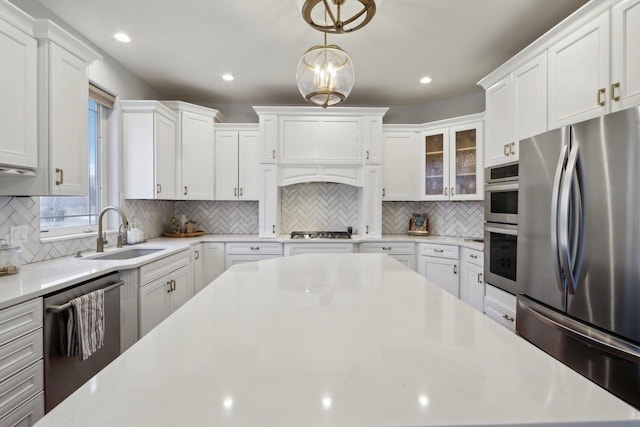 kitchen with white cabinetry, light countertops, appliances with stainless steel finishes, and a sink