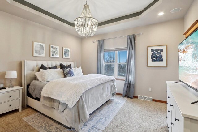 bedroom featuring visible vents, multiple windows, baseboards, and a tray ceiling