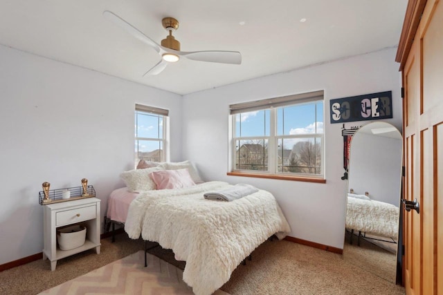 carpeted bedroom featuring a ceiling fan and baseboards