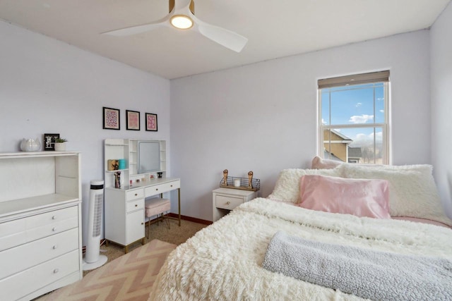 carpeted bedroom featuring baseboards and a ceiling fan