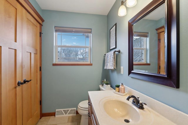 half bathroom with a wealth of natural light, visible vents, tile patterned flooring, and toilet