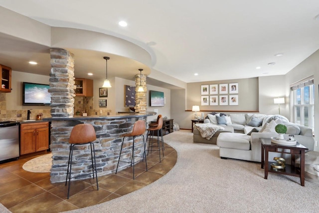 bar featuring wet bar, carpet, stainless steel dishwasher, and tile patterned flooring