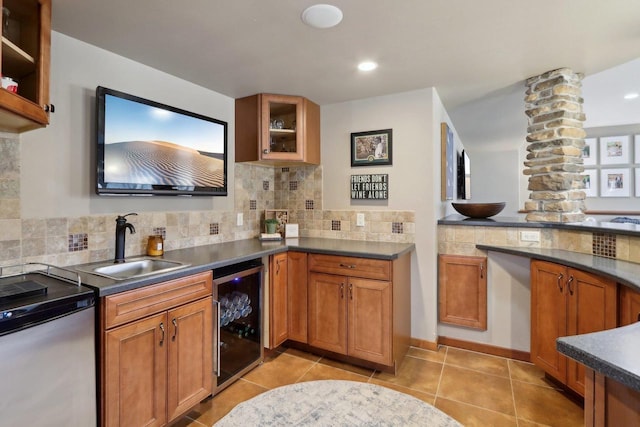 kitchen with brown cabinets, a sink, glass insert cabinets, wine cooler, and decorative backsplash