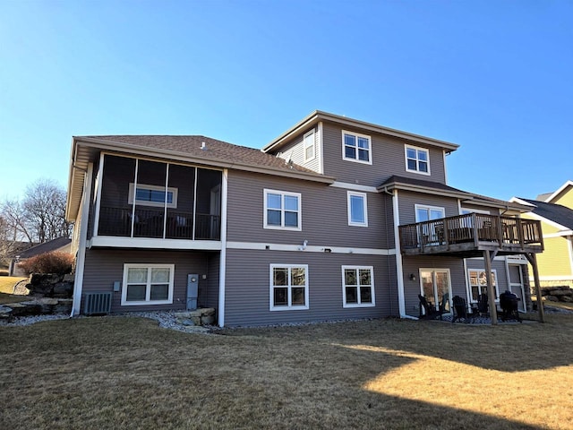 rear view of house featuring cooling unit, a yard, and a sunroom