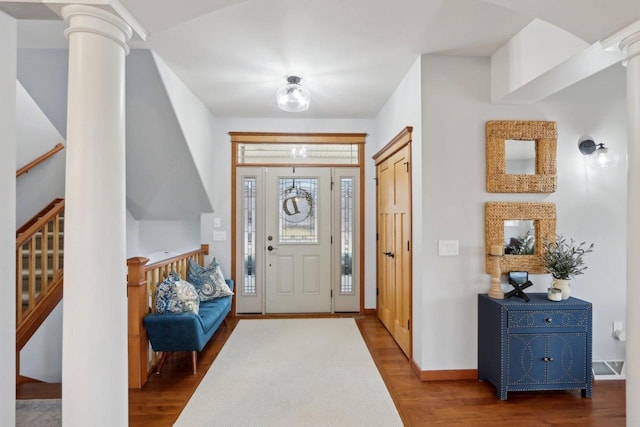 foyer with stairway, wood finished floors, baseboards, and ornate columns