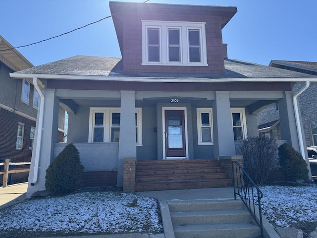 bungalow-style house with a shingled roof and covered porch