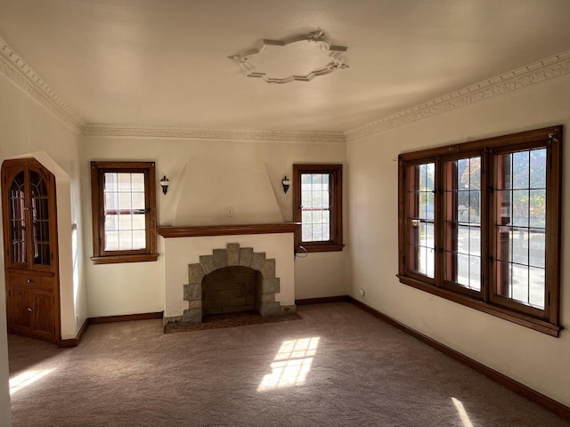 unfurnished living room with ornamental molding, a stone fireplace, carpet, and baseboards