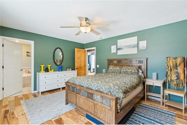 bedroom featuring a ceiling fan, a textured ceiling, ensuite bathroom, and wood finished floors