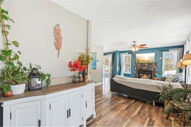 bedroom with a ceiling fan, dark wood-style flooring, access to outside, a textured ceiling, and a high end fireplace