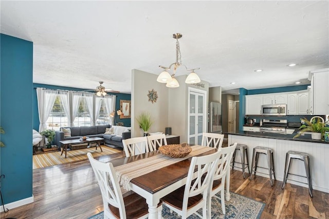 dining area featuring ceiling fan with notable chandelier, dark wood-style flooring, baseboards, and recessed lighting