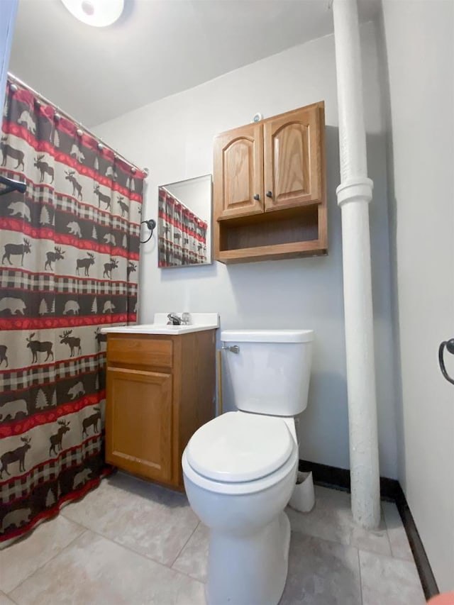 bathroom featuring tile patterned floors, vanity, toilet, and baseboards