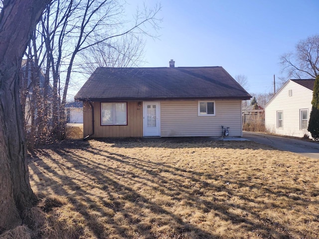 rear view of house featuring a chimney