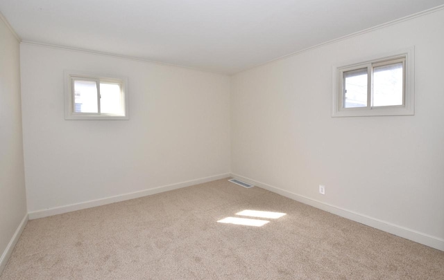 unfurnished room with carpet flooring, baseboards, crown molding, and visible vents