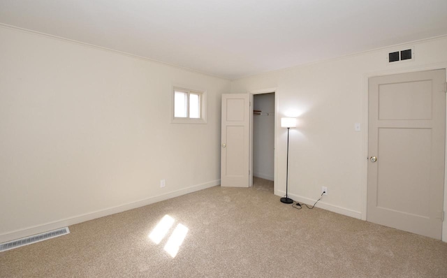 unfurnished bedroom with visible vents, light carpet, and baseboards