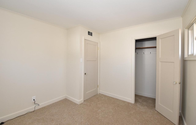 unfurnished bedroom with crown molding, light colored carpet, visible vents, and baseboards