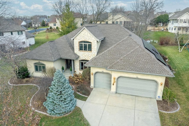 french provincial home featuring an attached garage, stone siding, a residential view, and roof with shingles