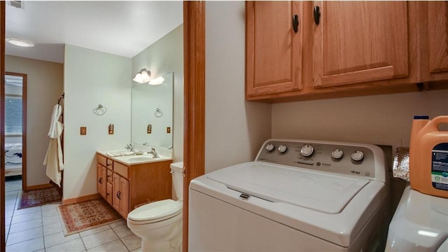 clothes washing area featuring light tile patterned floors, laundry area, a sink, and visible vents