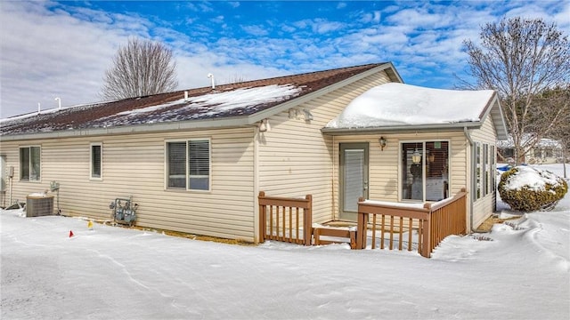 snow covered rear of property with central air condition unit