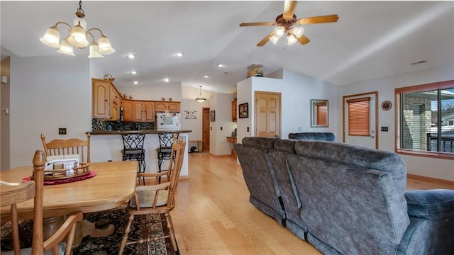 dining space featuring light wood-style floors, ceiling fan, and vaulted ceiling