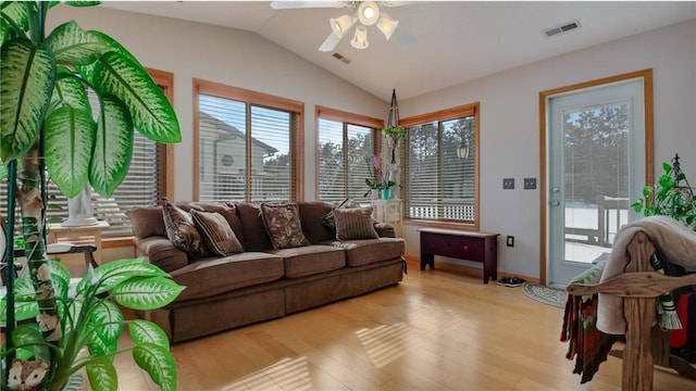 living room with a ceiling fan, visible vents, vaulted ceiling, and wood finished floors