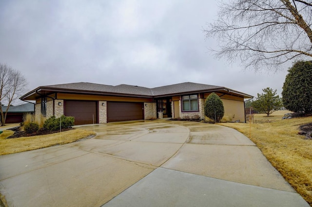 prairie-style home featuring an attached garage, concrete driveway, and a front yard