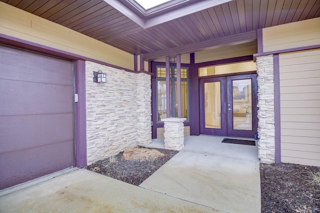 view of exterior entry featuring covered porch and stone siding