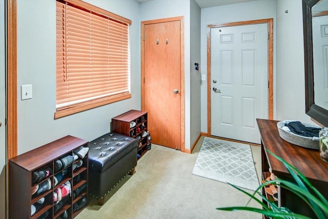 carpeted entryway featuring baseboards