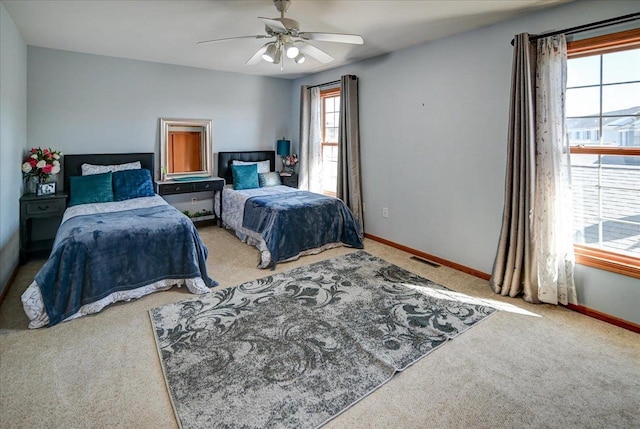 carpeted bedroom featuring visible vents, baseboards, and a ceiling fan