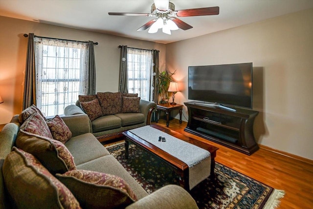 living room with baseboards, wood finished floors, and a ceiling fan