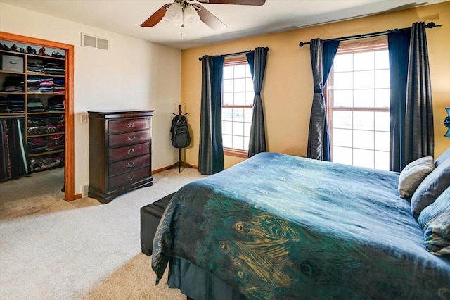 bedroom featuring visible vents, a walk in closet, baseboards, carpet flooring, and a closet