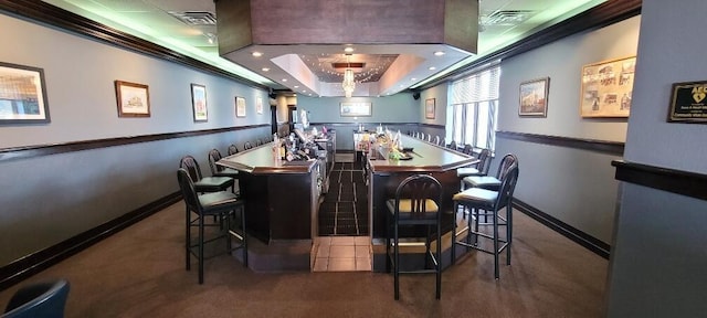 bar with carpet floors, a tray ceiling, visible vents, and a community bar