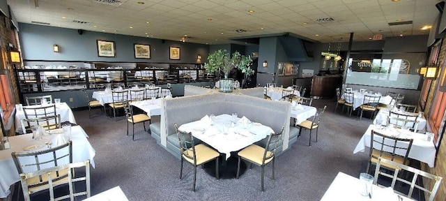 dining room with a drop ceiling and visible vents