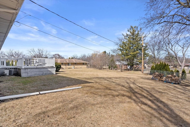 view of yard with central AC and fence