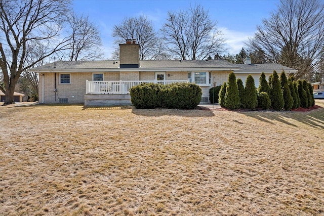 rear view of house with crawl space, brick siding, and a chimney