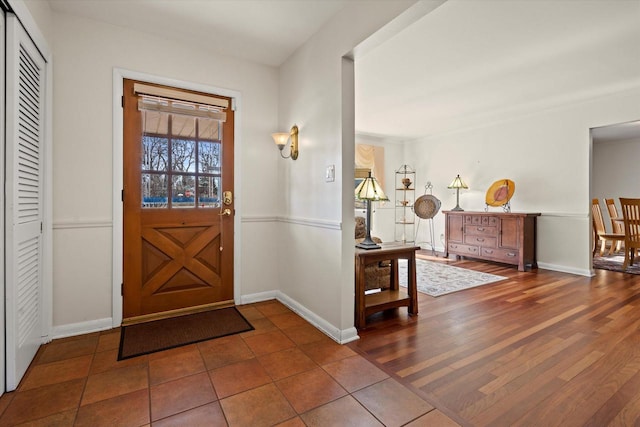 foyer entrance featuring baseboards and wood finished floors