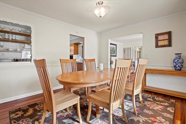 dining area with crown molding, baseboards, and wood finished floors