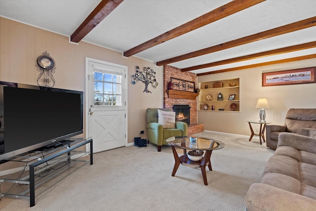 carpeted living area with beamed ceiling, a fireplace, baseboards, and built in shelves