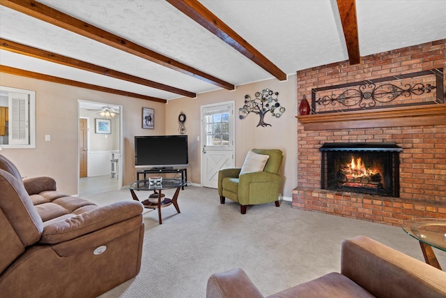 carpeted living area with beamed ceiling, a fireplace, and a textured ceiling