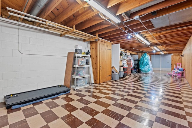 unfinished basement featuring tile patterned floors and concrete block wall