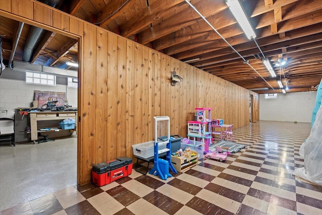 basement with tile patterned floors and wooden walls