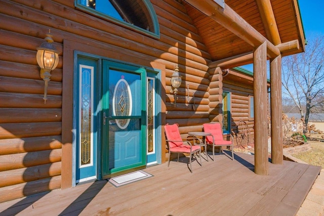 view of exterior entry featuring log siding