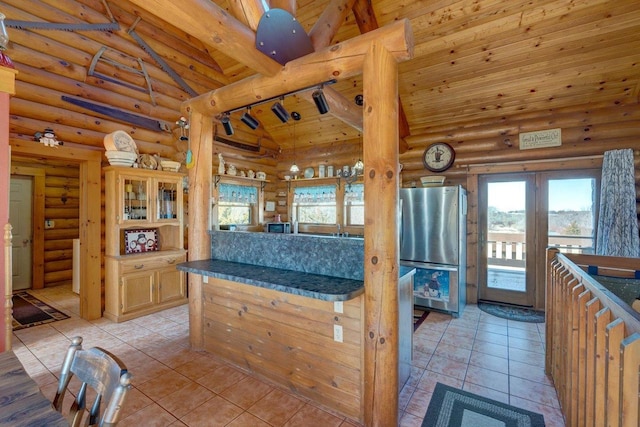 kitchen featuring wood ceiling, log walls, freestanding refrigerator, dark countertops, and rail lighting