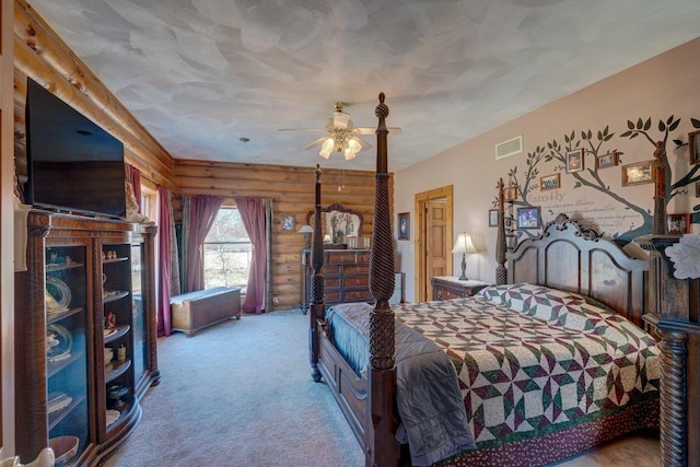 bedroom featuring rustic walls, carpet, visible vents, and ceiling fan