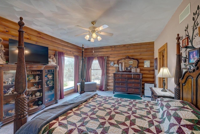 bedroom with a ceiling fan, visible vents, carpet flooring, and log walls