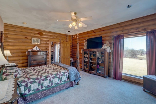 bedroom with a ceiling fan, rustic walls, and carpet flooring