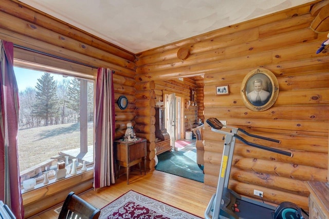 exercise area featuring rustic walls and wood finished floors