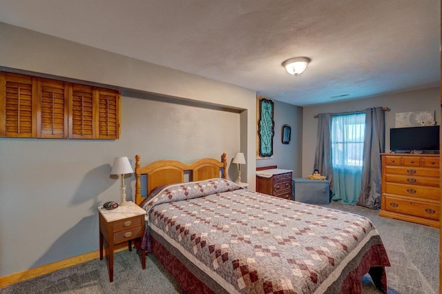 carpeted bedroom with visible vents, a textured ceiling, and baseboards