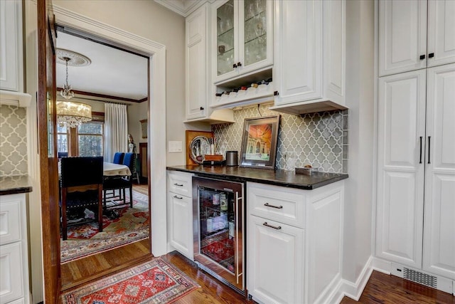 bar with wine cooler, visible vents, ornamental molding, tasteful backsplash, and dark wood finished floors